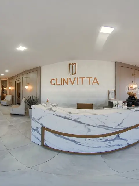 Recepção com balcão de mármore e o letreiro da Clinvitta